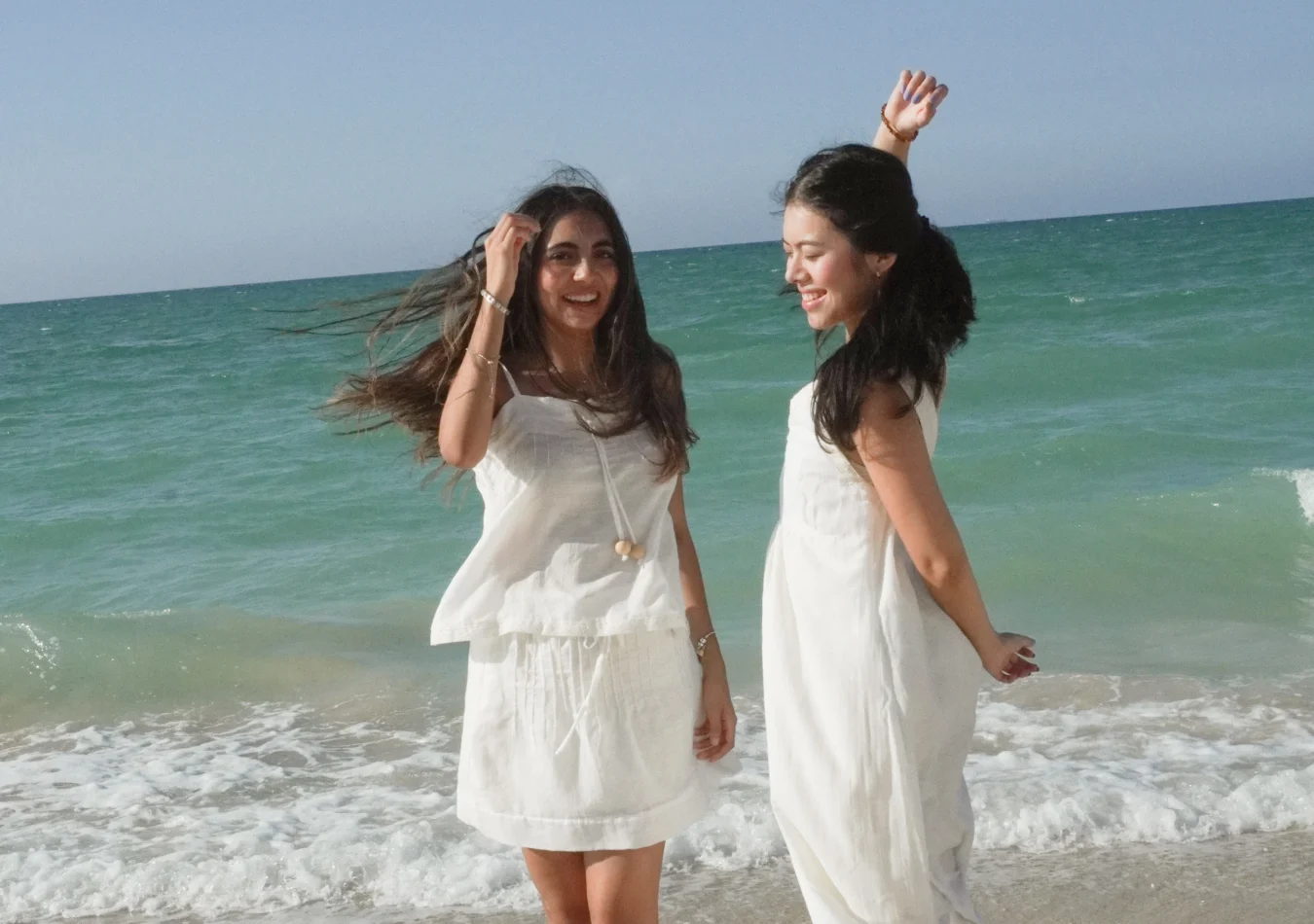 Dos mujeres con prendas blancas de la colección Volver junto al mar