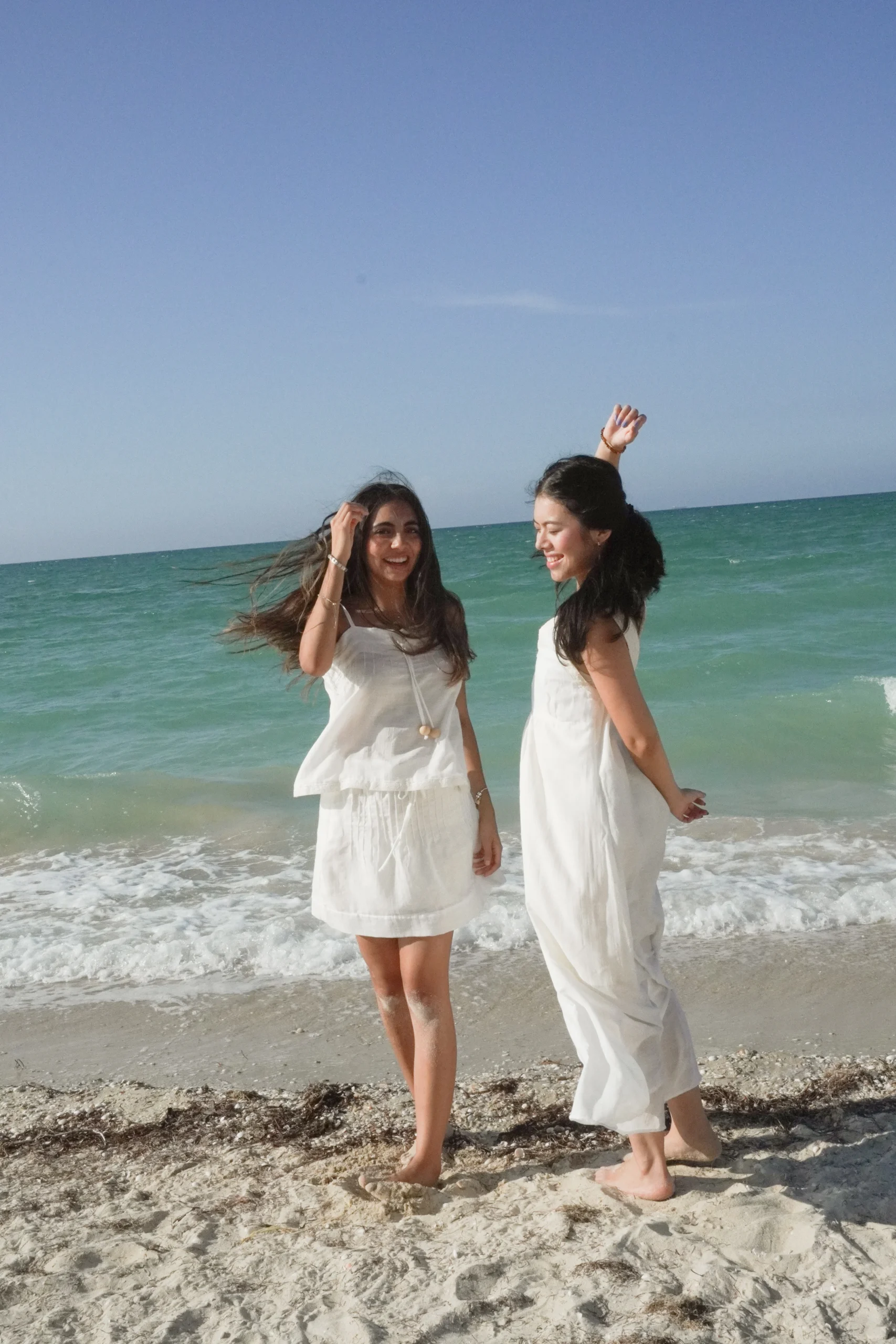 Dos mujeres con prendas blancas de la colección Volver junto al mar